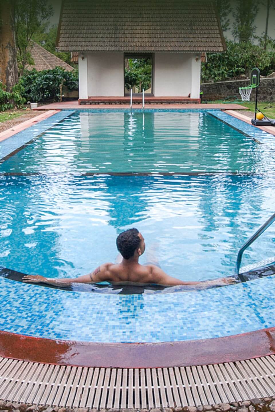 Open-air swimming pool at Misty Woods Resort Coorg surrounded by lush greenery and scenic plantation views.Relax and refresh at the serene swimming pool of Misty Woods Resort, where nature and comfort come together in the heart of Coorg.