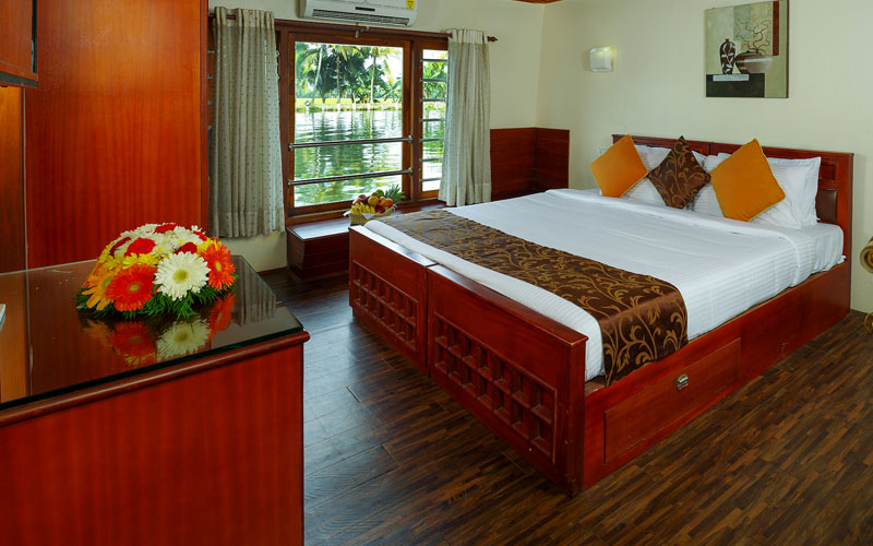 Well-designed air-conditioned bedroom with modern facilities and attached bathroom in Cruise Land houseboat Alleppey